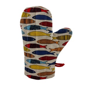 Könnte beinhalten: Ofenhandschuh mit farbenfrohem Fischmuster. Der Handschuh hat einen beigefarbenen Hintergrund mit Reihen verschiedener Fische in Rot-, Blau-, Gelb- und Brauntönen. Eine rote Schlaufe zum Aufhängen ist angebracht. Für den Küchengebrauch.