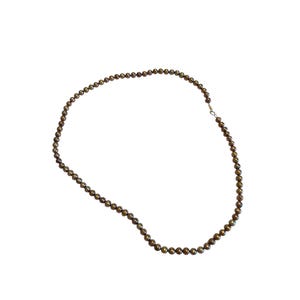 May include: A long necklace composed of small, dark brown beads. The beads are strung together, forming a continuous loop. The necklace is displayed against a white background, highlighting the jewelry's design and color.
