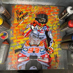 May include: Artwork of a motorcycle racer in a racing suit, helmet, and motorcycle. The artwork is on a dark background with spray paint cans surrounding it. The racer's name, "Marc Marquez," and the number "93" are visible.