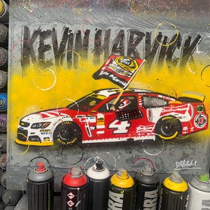 May include: A painting featuring a red and white race car with the number 4, the Budweiser logo, and the text "KEVIN HARVICK". The car is set against a yellow backdrop, with a flag that reads "Champion Kevin Harvick".