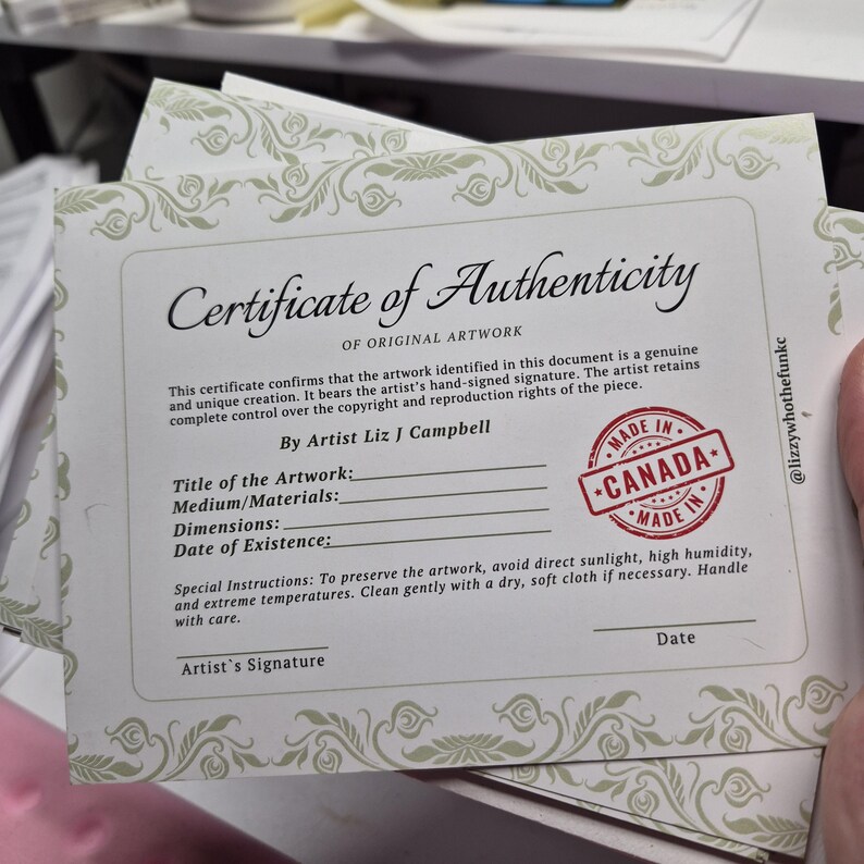 K&ouml;nnte beinhalten: Ein Stapel Echtheitszertifikate f&uuml;r Originalkunstwerke. Die Zertifikate haben einen dekorativen Rand und enthalten den Text "Certificate of Authenticity" und einen Stempel "Made in Canada". Der K&uuml;nstler ist Liz J Campbell.