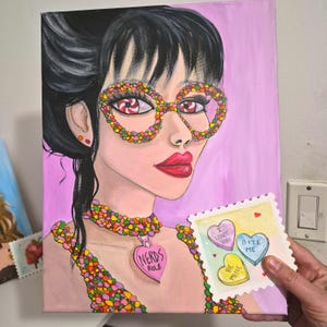 K&ouml;nnte beinhalten: Ein Pop-Art-Gem&auml;lde einer Frau mit zucker&uuml;berzogenen Brillen und einem Halskettenanh&auml;nger mit der Aufschrift "Nerds Rule". Sie h&auml;lt eine Karte mit herzf&ouml;rmigen S&uuml;&szlig;igkeiten mit den Aufschriften "I love you", "Bite me" und "Be mine". Der Hintergrund ist rosa.