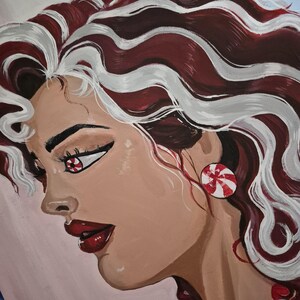K&ouml;nnte beinhalten: Portr&auml;t einer Frau mit rot-wei&szlig; gestreiften Haaren, Ohrringen und Augen im Candy-Thema. Die Frau hat rote Lippen und einen hellen Teint. Das Kunstwerk hat ein skurriles, festliches Thema.