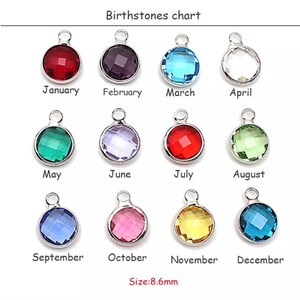 May include: Birthstone chart showing 12 different colored gemstones, each representing a month of the year. The gemstones are set in silver-toned metal charms, each measuring 8.6 mm in diameter.