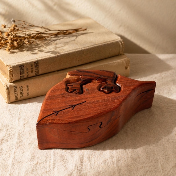 A hand-carved folk-art frog that hides a secret compartment — whimsical, tactile, and the kind of thing that sits on a desk and confuses every visitor.