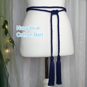 May include: Navy blue cotton belt with long tassels. The belt is displayed on a white mannequin. The text "Navy blue Cotton Belt" is visible on the image.