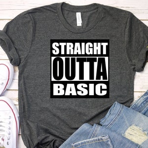 Puede incluir: Una camiseta gris oscuro con el texto "STRAIGHT OUTTA BASIC" impreso en blanco sobre un cuadrado negro.