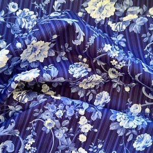 May include: Blue and white floral fabric with a striped background. The fabric has a vintage feel and is perfect for quilting, crafts, and home decor.