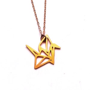 May include: A gold origami crane pendant necklace. The crane is a symbol of peace and good luck.