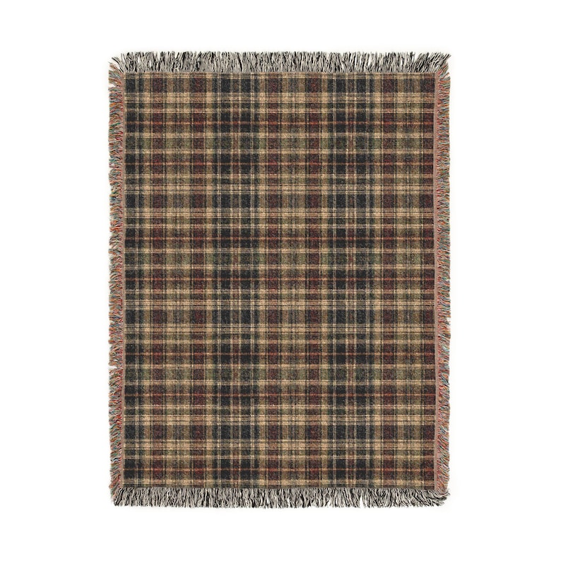 Puede incluir: Una manta tejida rectangular con un patr&oacute;n de cuadros oscuros en tonos negro, marr&oacute;n, beige y rojo apagado. La manta tiene una apariencia texturizada con l&iacute;neas horizontales y verticales visibles y bordes con flecos deshilachados.
