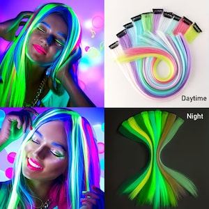 Könnte beinhalten: Eine Sammlung mehrfarbiger Haarverlängerungen mit schwarzen Clip-Befestigungen. Die Strähnen erscheinen bei Tageslicht in Pastelltönen und leuchten unter ultraviolettem Licht in hellen Neonfarben. Das Set enthält verschiedene Nuancen von Pink, Blau, Grün und Gelb.