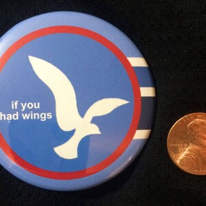 May include: A blue and red button with a white silhouette of a bird and the text "if you had wings".