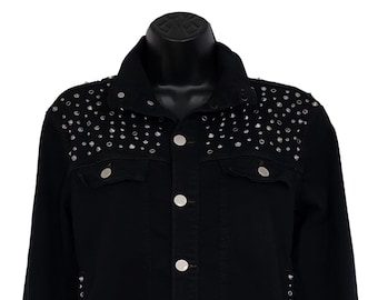 May include: A black denim jacket with silver studs on the shoulders, cuffs, and sides. The jacket has a classic jean jacket style with a button-up front and two pockets.