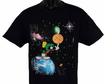 May include: Black t-shirt with a graphic print of a green cartoon character playing basketball in space. The character is standing on a blue planet with a starry background.
