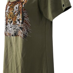 May include: A green short-sleeved t-shirt with a tiger face design made of rhinestones.