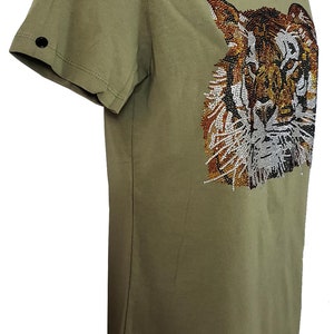 May include: A green short-sleeved t-shirt with a tiger face design made of rhinestones. The tiger's face is brown, orange, and white.