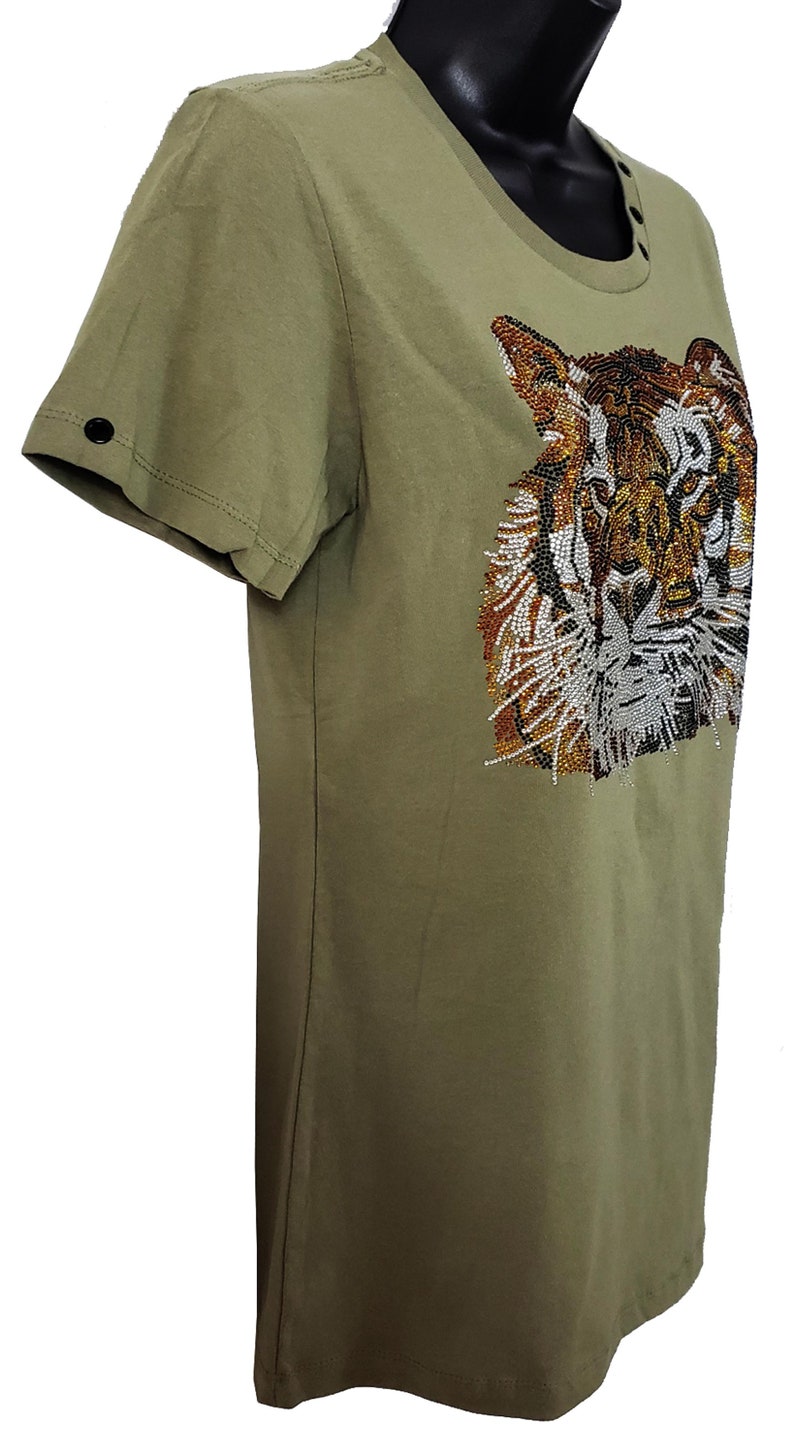 May include: A green short-sleeved t-shirt with a tiger face design made of rhinestones. The tiger's face is brown, orange, and white.