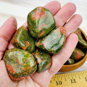 May include: A collection of six green and red tumbled stones. The stones are smooth and polished, with a variety of patterns and textures.