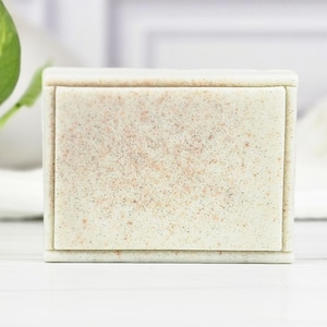May include: A white rectangular bar of soap with a speckled texture.