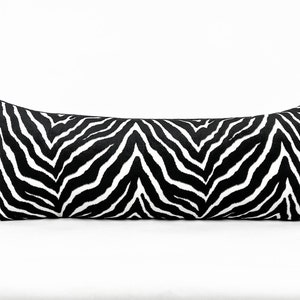 May include: Black and white zebra print lumbar pillow. The pillow is long and rectangular.