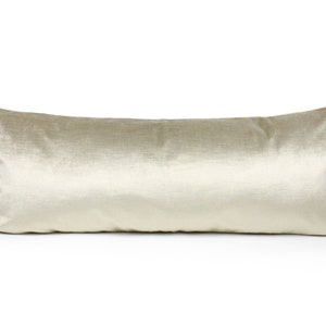 May include: A long, rectangular, cream-colored velvet pillow.