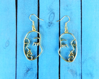 Pendientes colgantes con cara abstracta: estilo art déco dorado