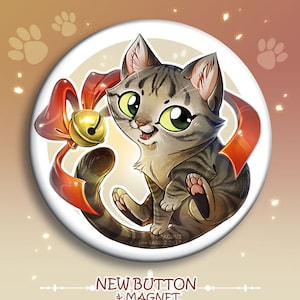 May include: A round button featuring a cartoon illustration of a gray tabby cat with green eyes wearing a red ribbon with a gold bell. The button has the text "NEW BUTTON & MAGNET" and "DRAGIBUZ / LORENE BARIOZ 2017" printed on it.