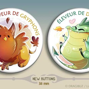 Peut inclure: Deux badges de 38 mm avec des illustrations de griffin et de dragon. Le griffin est brun et jaune et tient une feuille. Le dragon est vert et crache du feu. Le texte sur les badges est "Éleveur de Gryphons" et "Éleveur de Dragons".