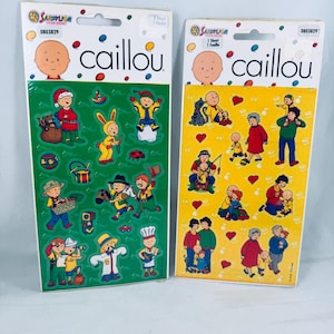 以下が含まれることがあります： Caillouのキャラクターが描かれたSandylionのステッカーシート2枚。左のシートは緑色の背景で様々なアクティビティのステッカーがあり、右のシートは黄色の背景で家族のステッカーと赤いハートが描かれています。