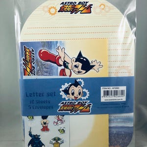 May include: Astro Boy letter set in a clear plastic package. The set includes 10 sheets, 5 envelopes, and stickers. The design features Astro Boy in various poses, with the Astro Boy logo in red, yellow, and blue.