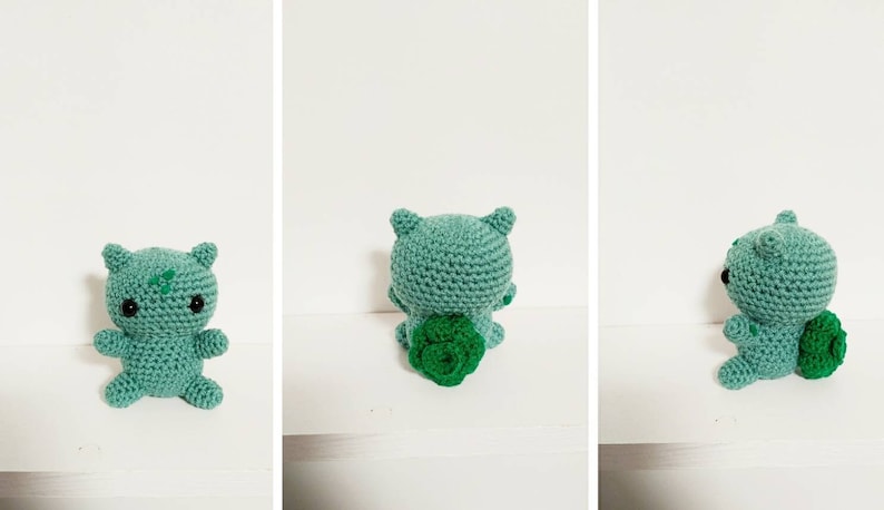 K&ouml;nnte beinhalten: Ein geh&auml;keltes Bulbasaur-Pl&uuml;schtier in Gr&uuml;n und Hellgr&uuml;n. Das Spielzeug steht auf einer wei&szlig;en Oberfl&auml;che.