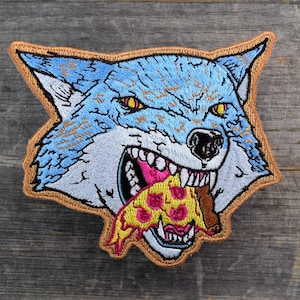 May include: A blue wolf with a fierce expression is biting into a slice of pizza with pink and yellow toppings. The wolf's mouth is open, showing sharp teeth. The pizza is dripping with cheese and sauce.