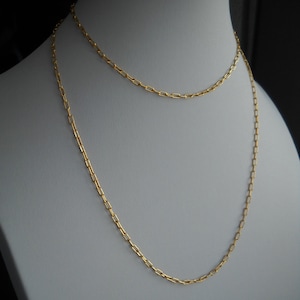 May include: A gold chain necklace with two strands of linked oval-shaped links.