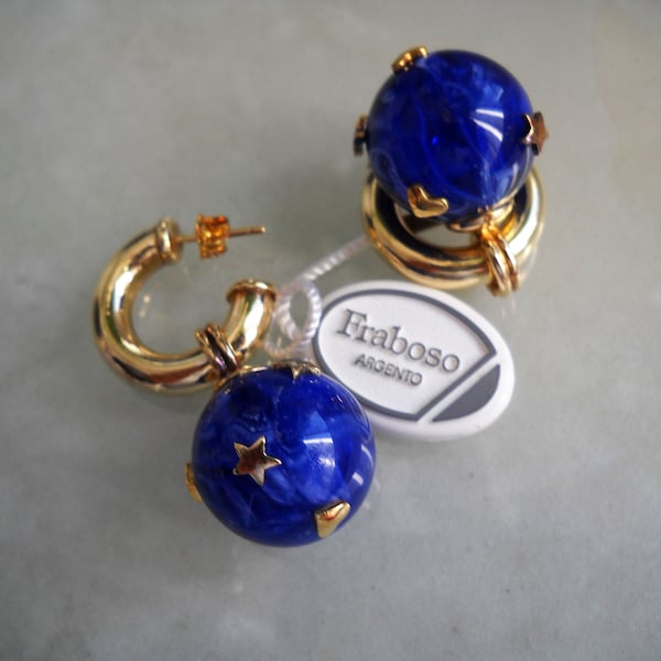 Boucles d’oreilles italiennes du début des années 90 « Fraboso ». Cerceau de goujon plaqué or où il est inséré une boule de résine bleue avec de petites étoiles et des cœurs en laiton