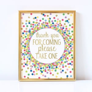 May include: A gold framed sign with a white background and colorful confetti. The sign says "thank you for coming please take one".
