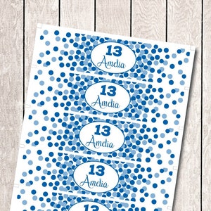 May include: Five blue and white can cooler labels with a confetti pattern. The labels have the text "13 Amelia" on them.