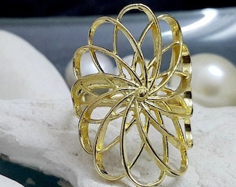 May include: A gold ring featuring a delicate, intricate design resembling a flower. The ring is displayed on a white starfish and a white shell.