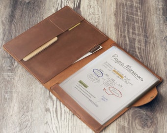 May include: A brown leather portfolio folder with a clear plastic insert for holding papers. The insert has a handwritten note that says "Project Milestones" and includes a timeline with dates and tasks.