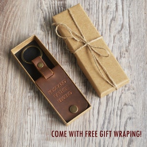 May include: Brown leather keychain with a silver key ring and the words "Husband Father Legend" embossed on the leather. The keychain is in a brown cardboard box with a twine bow.