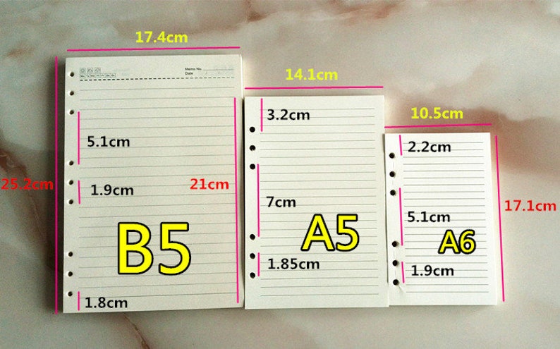 May include: Three different sizes of white lined paper notebooks with punched holes on the left side. The notebooks are labeled B5, A5, and A6. The measurements of each notebook are listed in centimeters.