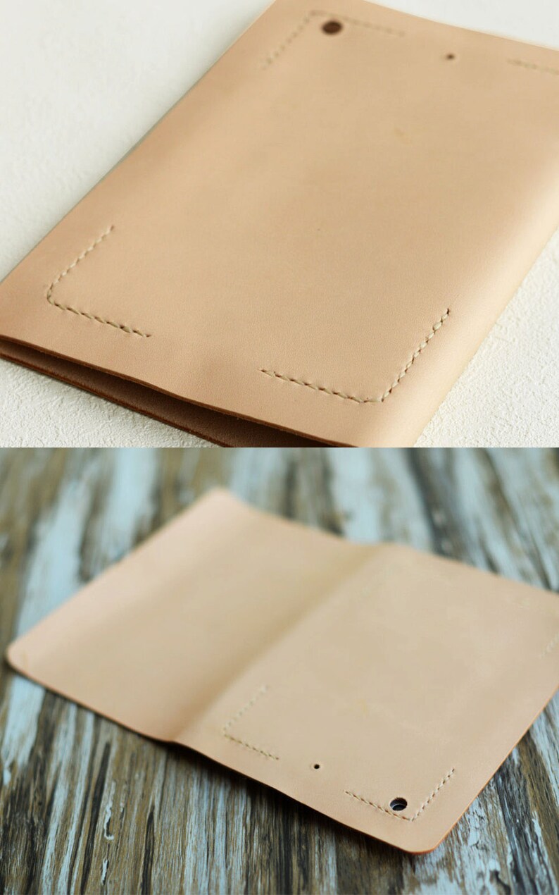 May include: A light brown leather notebook cover with stitching around the edges. The cover is folded in half and has two holes punched in the front.