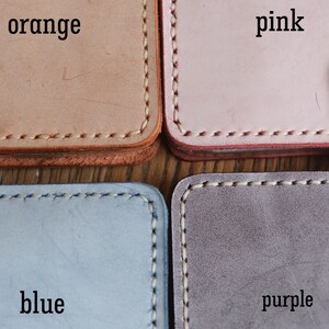 Op de afbeelding: Vier vierkante stukken leer in verschillende kleuren: oranje, roze, blauw en paars. Elk vierkant heeft witte stiksels rond de randen.