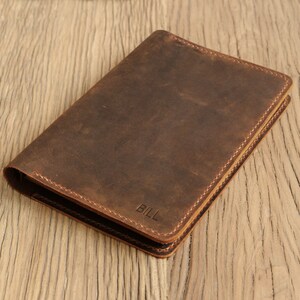 May include: A brown leather notebook with the name "BILL" embossed on the front.