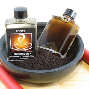 May include: Two small, square glass bottles with black caps, one filled with a clear liquid and the other with a dark brown liquid. The bottles are in a black bowl filled with dark brown granules. The label on one bottle reads "COFFEE + CONJURE OIL + LEGENDARYCONJURE.COM 1/2 FLUID OZ".