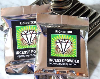 May include: Two silver foil pouches with black labels that read "Rich Bitch" and feature a diamond graphic. The labels also say "Incense Powder" and "legendaryconjure.com".