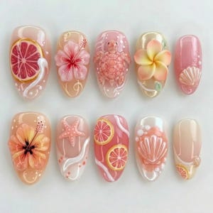May include: A set of ten press-on nails featuring 3D designs including a grapefruit slice, pink hibiscus flowers, a sea turtle, a plumeria flower, seashells, a starfish, and swirling white accents on a translucent pink and peach base.