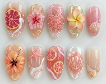 Puede incluir: Un juego de diez uñas postizas con diseños en 3D que incluyen una rodaja de pomelo, flores de hibisco rosas, una tortuga marina, una flor de plumeria, conchas, una estrella de mar y detalles en blanco sobre una base rosa y melocotón.