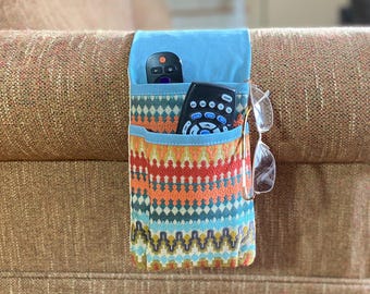 Soporte para mando a distancia con doble bolsillo. Organizador extralargo para el reposabrazos.