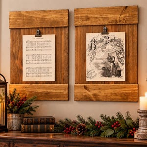 May include: Two rectangular wooden wall plaques with a medium brown finish, each featuring a metal clip at the top. The left plaque holds a sheet of music titled The Christmas Tree, and the right plaque displays a vintage print titled Birdie Darlings.