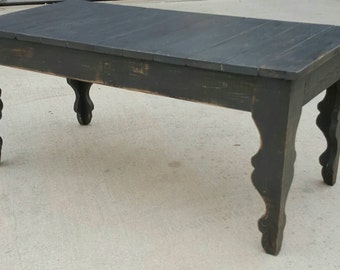 Shabby chic farmhouse style coffee table with gray distressed, antiqued finish. Decorative scroll style legs.